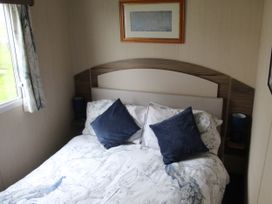 A bedroom with a bed and bedside lamps at Kent Coast Holiday Park - Holiday Accommodation 22252, Rochester, Kent