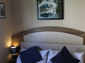 A bedroom with a bed and lamp at Kent Coast Holiday Park - Holiday Accommodation 22252, Rochester, Kent