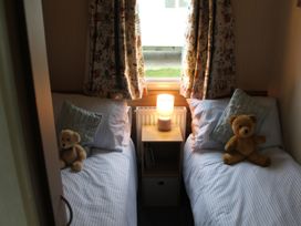 A bedroom with two beds and a nightstand at Kent Coast Holiday Park - Holiday Accommodation 22252, Rochester, Kent