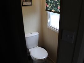 A bathroom with a toilet and window at Kent Coast Holiday Park - Holiday Accommodation 22252, Rochester, Kent