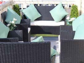 An outdoor seating area with wicker furniture at Kent Coast Holiday Park - Holiday Accommodation 22252, Rochester, Kent