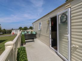An outdoor space with a deck and seating area at Estuary View in Allhallows