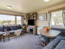 A living room with a table and sofa at Estuary View in Allhallows
