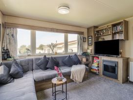 A living room with a sofa and television at Estuary View in Allhallows