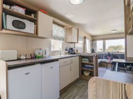 A kitchen with appliances and seating area at Estuary View in Allhallows