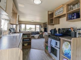 A kitchen with a stove and a dining area at Estuary View in Allhallows