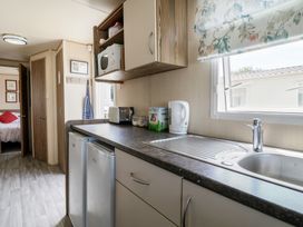 A kitchen with appliances and sink at Estuary View in Allhallows