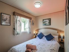 A bedroom with a bed and artwork at Estuary View in Allhallows