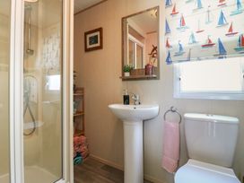 A bathroom with a shower, toilet, and sink at Estuary View in Allhallows