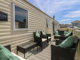 An outdoor seating area with chairs and a table at Estuary View in Allhallows