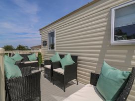 An outdoor seating area with chairs and cushions at Estuary View in Allhallows