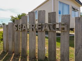 A wooden sign that says Sea Reach in front of a house at Estuary View in Allhallows
