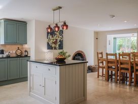 A kitchen with cabinets and a dining area at Harbins Farm in Glanvilles Wootton Nr. Sherborne