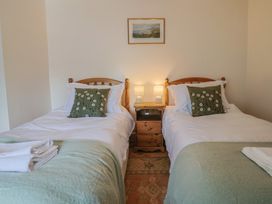 A bedroom with two beds and a bedside table at Harbins Farm Glanvilles Wootton Nr. Sherborne