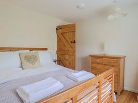 A bedroom with a double bed and wooden furniture at Harbins Farm Glanvilles Wootton Nr. Sherborne