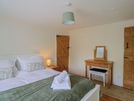 A bedroom with a bed and a dressing table at Harbins Farm in Glanvilles Wootton Nr. Sherborne