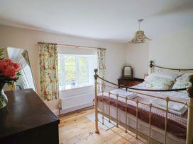 A bedroom with a bed and window at Harbins Farm, Glanvilles Wootton Nr. Sherborne
