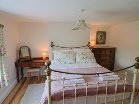 A bedroom with a bed and dressers at Harbins Farm, Glanvilles Wootton Nr. Sherborne