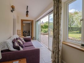 A living room with a sofa and sliding door at Harbins Farm in Glanvilles Wootton Nr. Sherborne