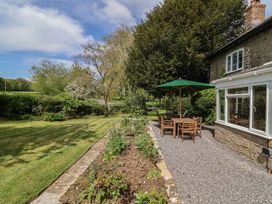 A garden with a table and chairs under an umbrella at Harbins Farm, Glanvilles Wootton Nr. Sherborne