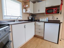 A kitchen with cabinets, sink, microwave, and countertop at Winchester - 244