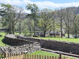 A view of trees and stone walls with a railway track at Pandora in Holmrook