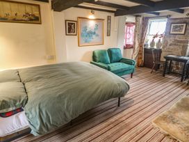 A bedroom with a bed and sofa at Ninevah in St. Ives