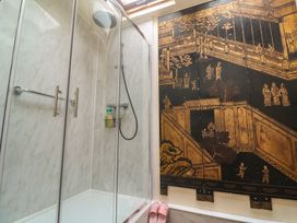 A shower with glass door and wall art at Ninevah in St. Ives