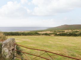 A grassy area with a gate and view of the sea at Ninevah in St. Ives