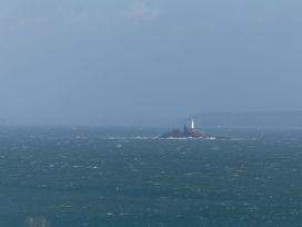 A lighthouse on a rock surrounded by ocean at Ninevah St. Ives
