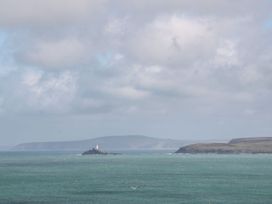 A view of ocean with an island and lighthouse at Ninevah in St. Ives