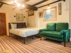 A bedroom with a bed and a green sofa at Ninevah Lelant