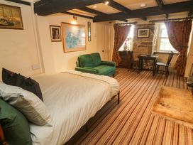 A bedroom with a bed and a green couch at Ninevah in Lelant