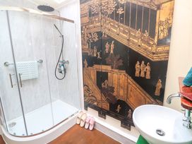 A bathroom with a shower and decorative wall art at Ninevah Lelant
