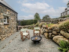 An outdoor seating area with two chairs and a fire pit at The Byre in Conwy