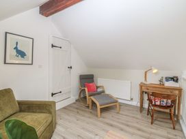 A snug with a chair, desk, and radiator at The Byre in Conwy