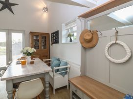 A dining room with a table and chairs at The Byre in Conwy