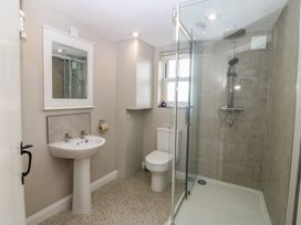 A bathroom with a sink, toilet, and shower at The Byre in Conwy