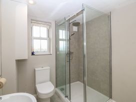 A bathroom with a shower, toilet, and sink at The Byre in Conwy