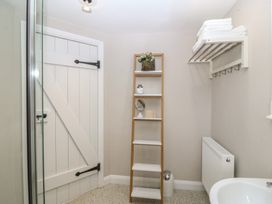 A bathroom featuring a shower, towel shelf, and ladder at The Byre in Conwy