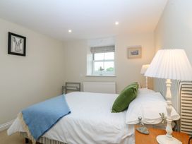 A bedroom with a bed and lamp at The Byre in Conwy