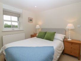 A bedroom with a double bed and lamps at The Byre in Conwy