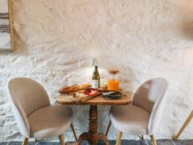 A small dining area with a wooden table and chairs at Little Oak near Tal-Y-Bont