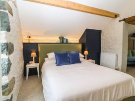 A bedroom with a bed and nightstands at Little Oak near Tal-Y-Bont