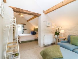 A bedroom with a bed, chair, and lamp at Little Oak near Tal-Y-Bont