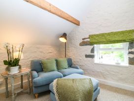 A snug with a sofa and a plant at Little Oak near Tal-Y-Bont