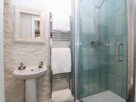 A bathroom with a sink, shower stall, towel rail, and mirror at Little Oak near Tal-Y-Bont