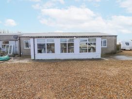 An outdoor view of a building with windows and gravel at Hen Fecws, Rhoshirwaun near Sarn Meyllteyrn