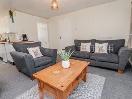 A living room with sofas and a coffee table at Hen Fecws Rhoshirwaun near Sarn Meyllteyrn