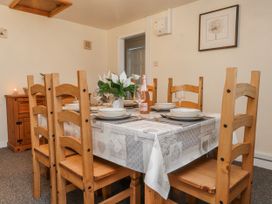 A dining room with a wooden table and chairs at Hen Fecws Rhoshirwaun near Sarn Meyllteyrn